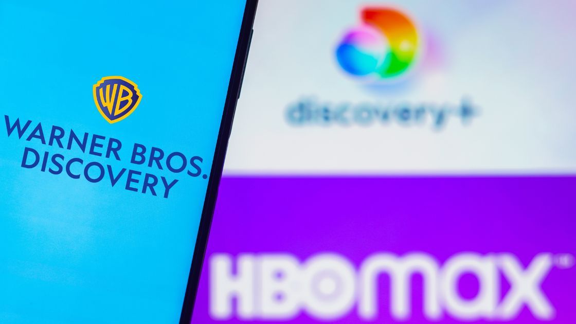August 5, 2022, Brazil. In this photo illustration, the Warner Bros. Discovery logo is displayed on a smartphone screen and in the background, the HBO Max and Discovery Plus logos